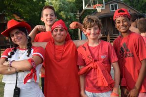 female counselor with red cowboy hat on and 4 male campers with red shirts