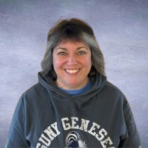 Melissa Headshot of a woman with gray shoulder length hair and a gray hooded sweatshirt