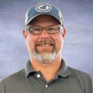 Ryan Headshort of a man with a blue baseball cap on, glasses and a gray goatee